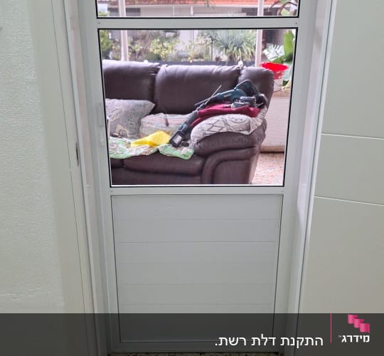 דלת אלומיניום עם חלון זכוכית וכלי עבודה על הרצפה